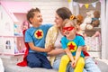 Happy family. A young woman plays with her children in superheroes Royalty Free Stock Photo