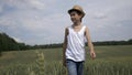 Happy farmer boy in a hat is walking across the field, outdoors Royalty Free Stock Photo