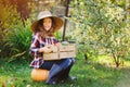 Happy farmer child girl with autumn harvest - organic pumpkins, carrots and zuccini