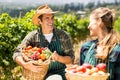 Happy farmer couple holding baskets of vegetables and fruits Royalty Free Stock Photo