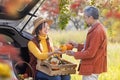 Happy farmer family carrying organics homegrown produce harvest with apple, squash and pumpkin while selling at the car trunk in Royalty Free Stock Photo