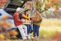 Happy farmer family carrying organics homegrown produce harvest with apple, squash and pumpkin while selling at the car trunk in Royalty Free Stock Photo