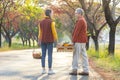 Happy farmer family carrying organics homegrown produce harvest with apple, squash and pumpkin while walking along country road Royalty Free Stock Photo