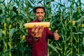 Happy farmer with hat looking at camera with a corn in his hand Royalty Free Stock Photo