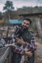 A happy farmer holding a cute goatling