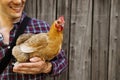 The farmer hugs a chicken. pleasant man is hugging a cock. close up shot emotions.