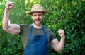 Happy farmer man in farmers hat and apron make winning gesture in garden aoutdoors Royalty Free Stock Photo