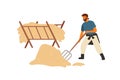 Happy farmer, peasant or rancher man working with pitchfork near manger full of hay. Agricultural worker making haystack