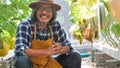 Happy farmer sitting in melons farm