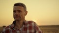 Happy farmer standing in wheat field at golden sunset hour. Agronomist portrait Royalty Free Stock Photo