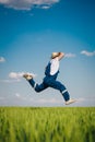 Happy farmer in the wheat against blue sky with white clouds