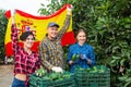 Happy farmers holding Spain flag in garden