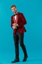 Happy fashion model wearing red velvet tuxedo and walking Royalty Free Stock Photo