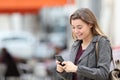 Happy teen texting on cell phone walking in the street