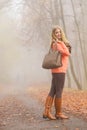 Happy fashion woman with handbag in autumn park Royalty Free Stock Photo