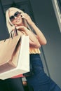 Happy fashion woman with shopping bags calling on mobile phone Royalty Free Stock Photo