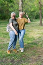 An elderly mother and an adult daughter, very much alike, stand in the park on a sunny day and laugh. Royalty Free Stock Photo