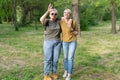 An elderly mother and an adult daughter, very much alike, stand in the park on a sunny day and laugh. Royalty Free Stock Photo