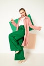 Happy fashionable woman in green pants in studio with white background