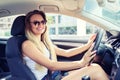 Happy fashionable young woman driving her new modern car