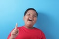 Happy fat Asian boy pointing finger up, having idea gesture Royalty Free Stock Photo