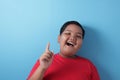 Happy fat Asian boy pointing finger up, having idea gesture Royalty Free Stock Photo