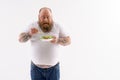 Happy fat guy eats vegetables Royalty Free Stock Photo