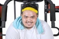 Happy fat man sitting on the exercise machine Royalty Free Stock Photo