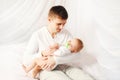 Happy father with baby on bed home bedtime