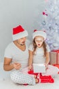 Happy Father and Baby with Christmas Gift near the Christmas Tree at home. Child opening a Gift Box Royalty Free Stock Photo