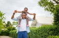 Happy father carrying daughter on shoulders, Cheerful african american girl on the shoulders of his father Royalty Free Stock Photo