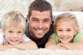 Happy father and children lying on the floor Royalty Free Stock Photo