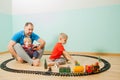 Happy father and children play a toy railway Royalty Free Stock Photo