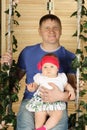 Happy father with cute baby sits on swing