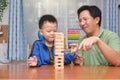 Happy father and cute little boy child excited with wooden block Jenga game, Dad and son spending quality time together playing Royalty Free Stock Photo