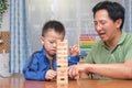 Happy father and cute little boy child excited with wooden block Jenga game, Dad and son spending quality time together playing Royalty Free Stock Photo