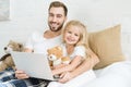 Happy father and cute little daughter using laptop together and smiling at camera Royalty Free Stock Photo