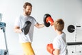 happy father and cute little son boxing together