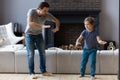 Happy father dancing with little son in modern living room Royalty Free Stock Photo