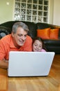 Father and daughter looking at laptop screen Royalty Free Stock Photo