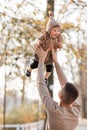 Happy father and daughter playing while walking in a beautiful autumn park. Ideal weekend father with his little daughter. father