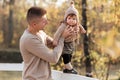 Happy father and daughter playing while walking in a beautiful autumn park. Ideal weekend father with his little daughter. father