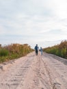 Happy father and daughter running jumping having fun on empty autumn sea beach. Dad and child walking on white sand Royalty Free Stock Photo