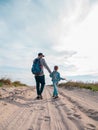 Happy father and daughter running jumping having fun on empty autumn sea beach. Dad and child walking on white sand Royalty Free Stock Photo