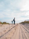 Happy father and daughter running jumping having fun on empty autumn sea beach. Dad and child walking on white sand Royalty Free Stock Photo