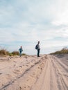 Happy father and daughter running jumping having fun on empty autumn sea beach. Dad and child walking on white sand Royalty Free Stock Photo