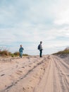 Happy father and daughter running jumping having fun on empty autumn sea beach. Dad and child walking on white sand Royalty Free Stock Photo