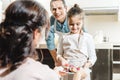 happy father with daughter showing plate with pancakes to mother