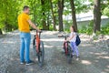 Happy father with daughter stand with bicycles in the park. Family spending time together Royalty Free Stock Photo