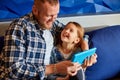 Happy father with daughter using tablet computer in living room, at sofa at home Royalty Free Stock Photo